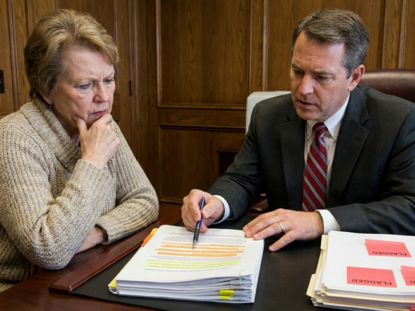 Cautious Boise seller reviewing purchase offer with real estate attorney, examining concerning clauses with serious protective expressions. Attorney pointing to problematic language—excessive contingencies, unrealistic timelines, financing concerns, unusual demands. Seller alarmed at nearly overlooked provisions. Attorney's protective stance identifying risky terms before acceptance. Contract pages with multiple highlighted warnings. Seller's trusting expression shifting to guarded awareness. Attorney explaining negotiation leverage and red flag implications. Professional guidance preventing disadvantageous acceptance. Contract scrutiny revealing buyer strategies requiring careful response.